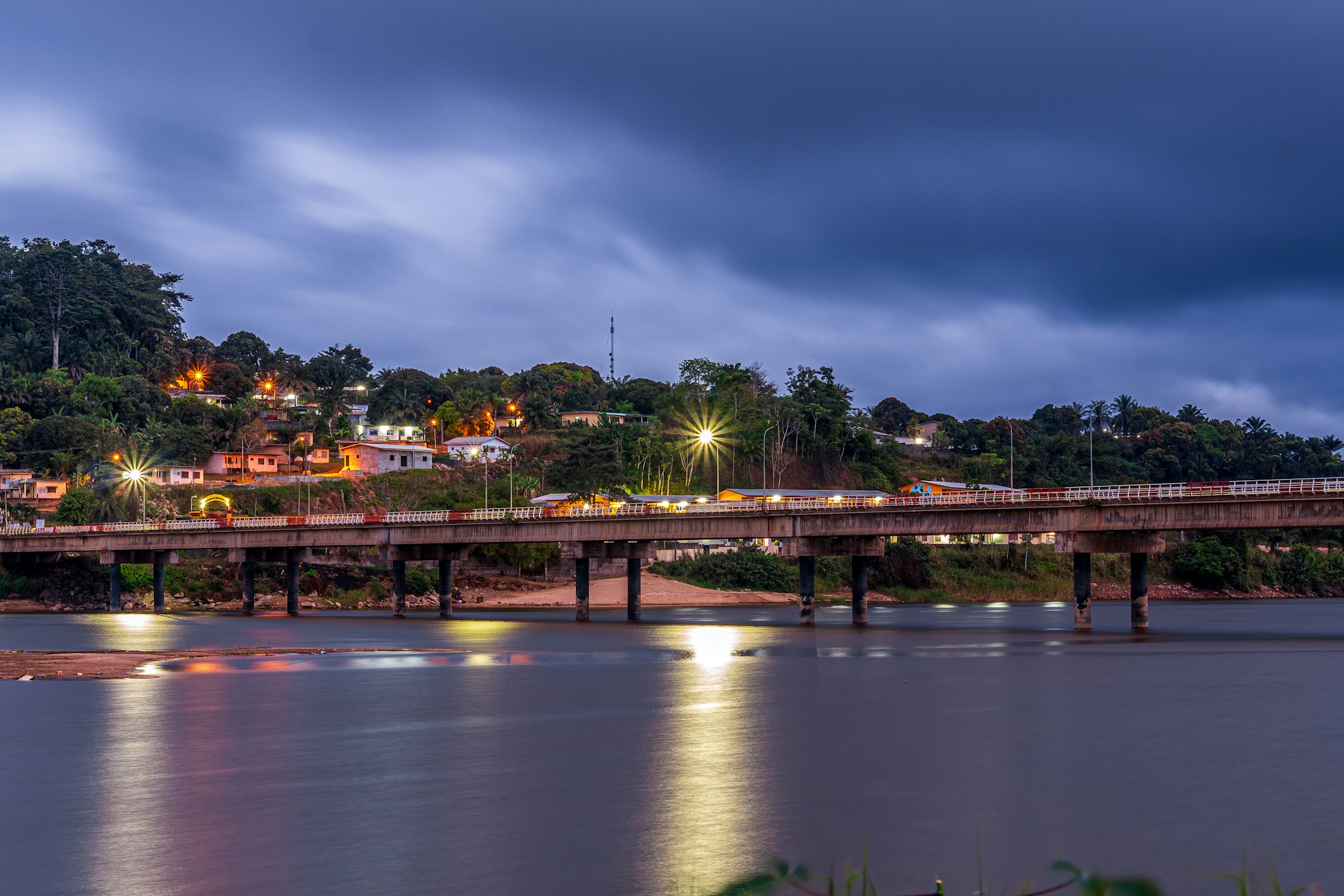 Waterfront and bridge lit up at dusk in Gabon